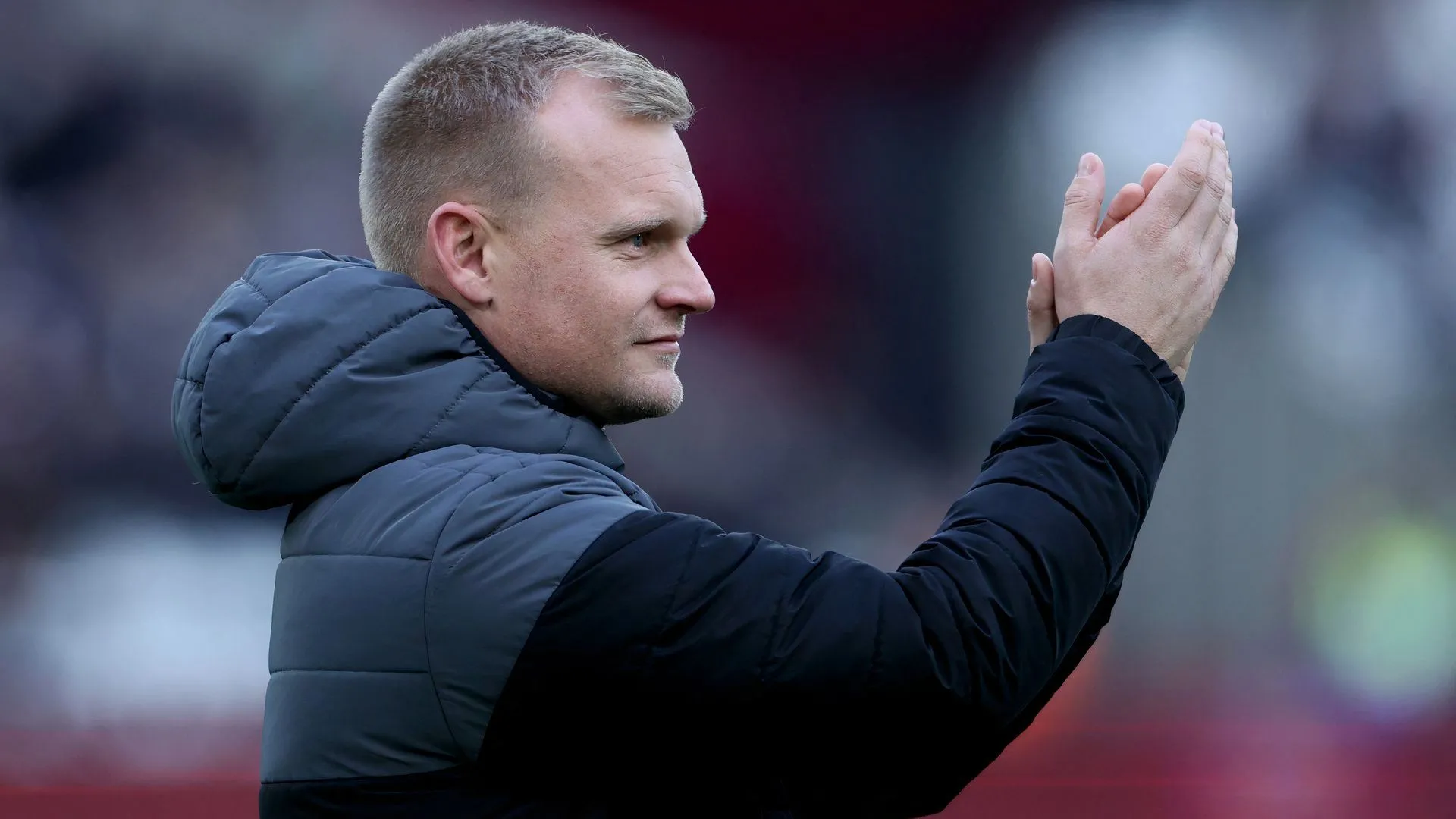 Liam Manning vỗ tay động viên cầu thủ Norwich City trong một trận đấu căng thẳng tại Carrow Road